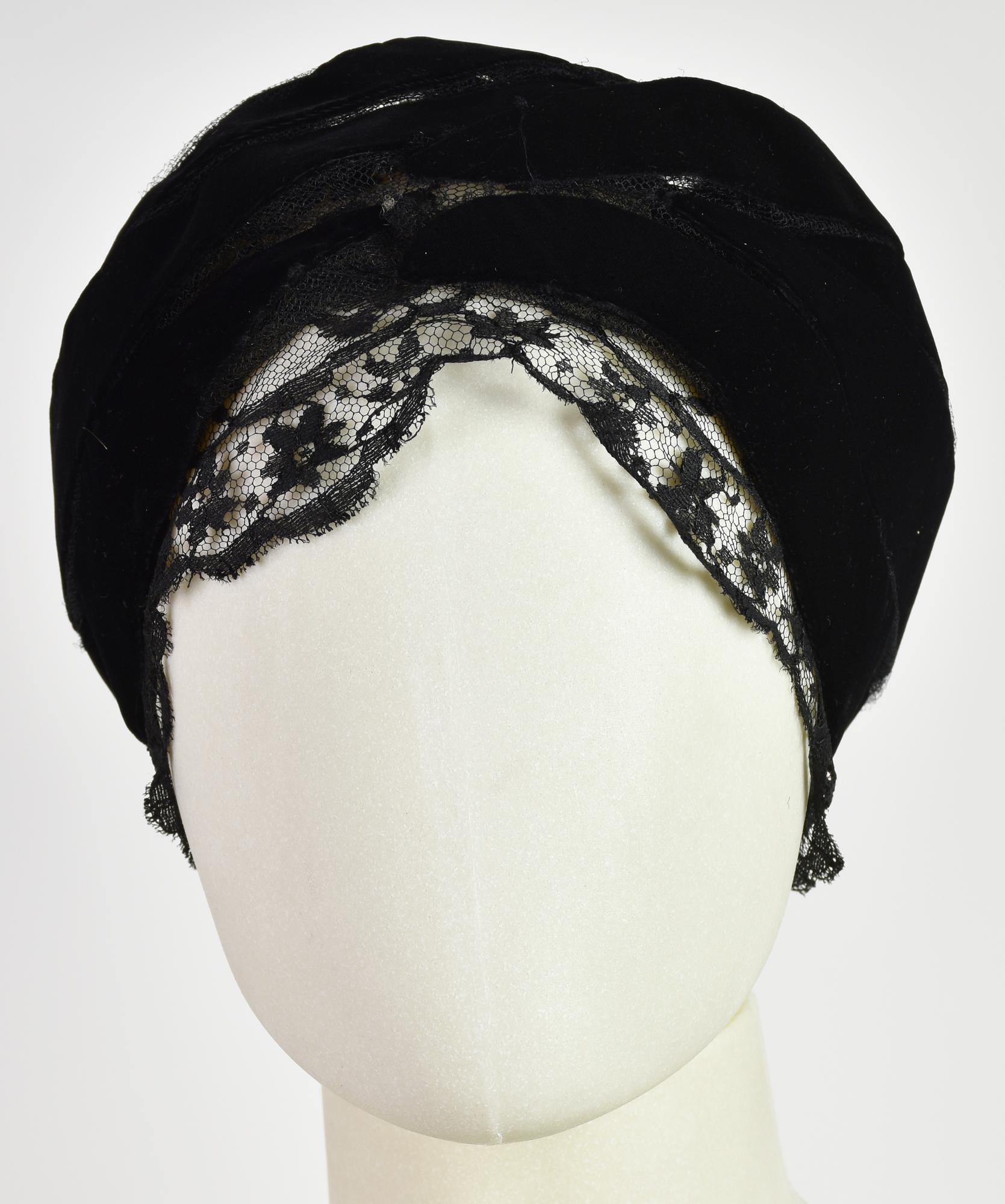 Paulette TURBAN DESCRIPTION: Turban in black velvet with lace inserts. 1960s....