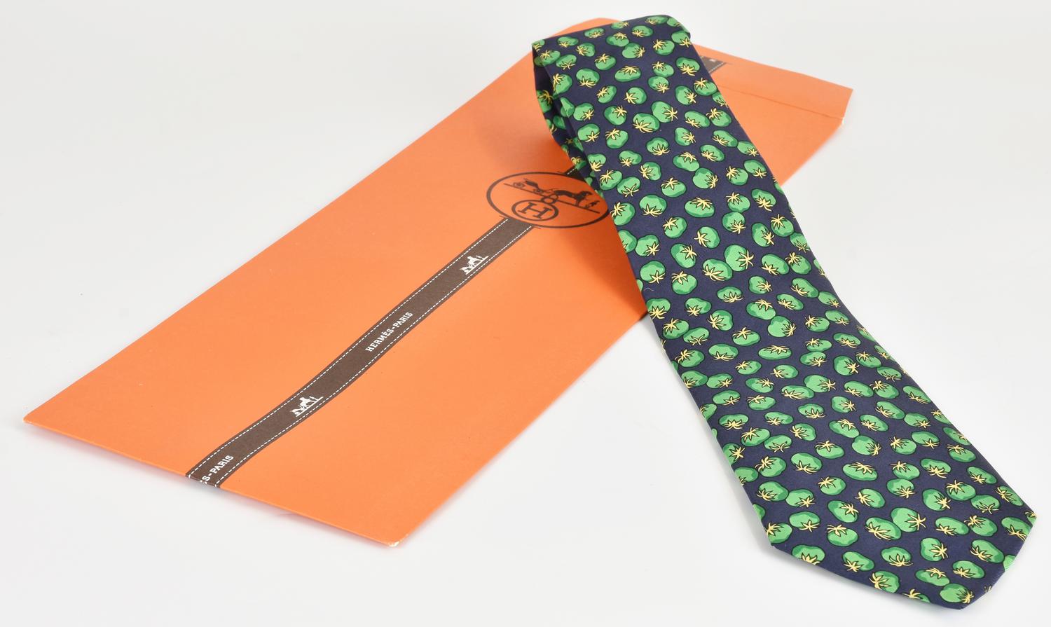 Hermes SILK TIE DESCRIPTION: Silk tie with a patterned design on a blue...